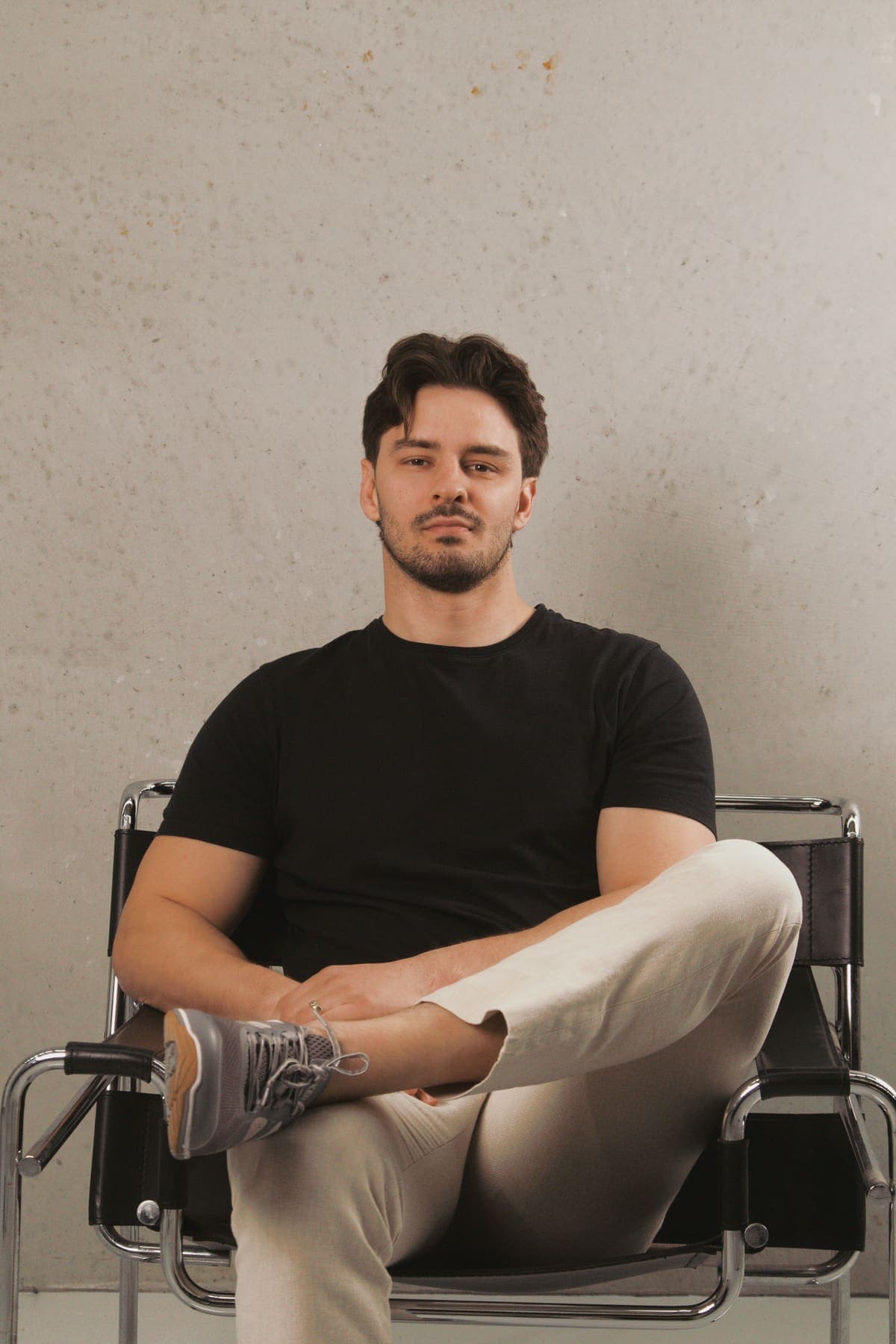 Luke Marinovic seated in a steel chair with his legs crossed, looking at the camera.